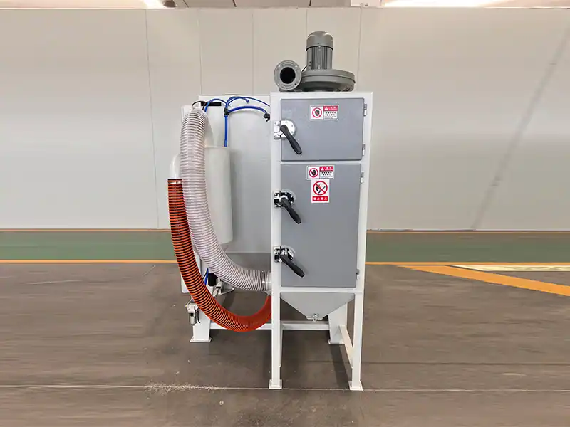 Rear view of TS9060 suction blasting cabinet showing cabinet structure and abrasive recovery system.